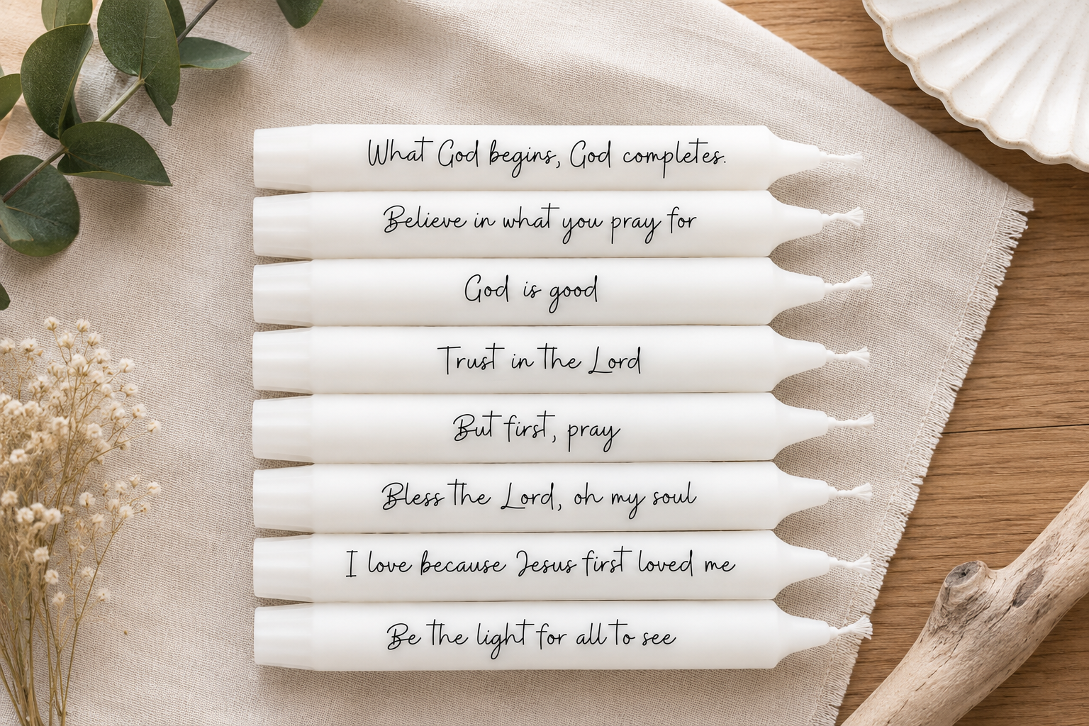 weiße Stabkerzen mit christlichem Schriftzug